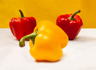 Composition of fresh harvest Bulgarian pepper on a yellow backround