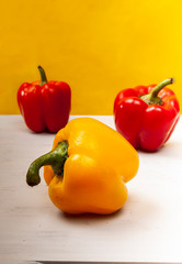 Composition of fresh harvest Bulgarian pepper on a yellow backround