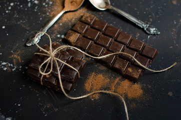 pieces of dark chocolate tied with string and sprinkled with cocoa powder with dried oranges
