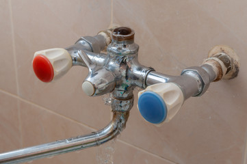 broken faucet in the bathroom from which the water flows.