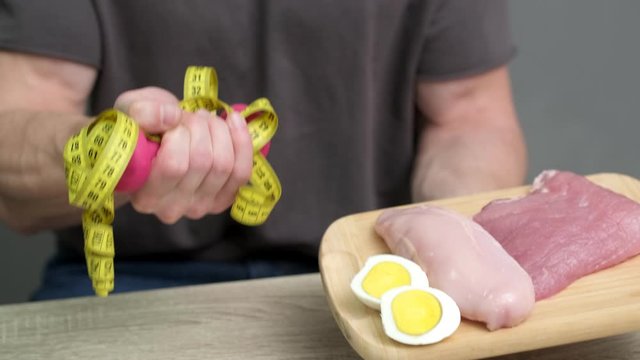 Healthy eating concept. Man of athletic build eats healthy food high in protein