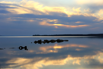 stones in river on sunset background