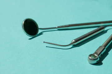 dental implantation tools close up: torque wrench, implant depthometer and dental mirror on blue background. copy space, horizontal,  selected focus