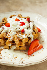 belgian waffles made of whole grain flour with whipped cream, strawberries and chocolate flakes. vertical