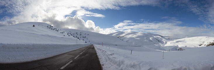 Mountain road with snow on the side and side of it. After passing the snow plow machine.