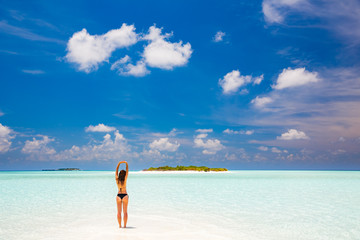 Young woman in bikini enjoing the beautiful ocean beach on Maldives