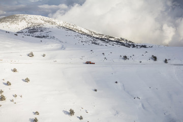Snow plow machine working on a mountain road in the Pyrenees. Close to the La Molina ski slope.