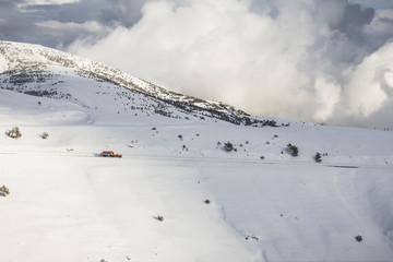 Snow plow machine working on a mountain road in the Pyrenees. Close to the La Molina ski slope.