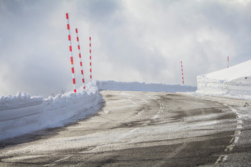 Mountain road with snow on the side and side of it. After passing the snow plow machine. On the...