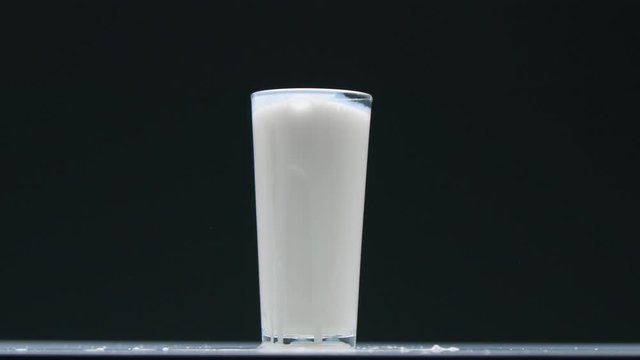 Side view blueberry falling into the glass with milk and make a splash closeup slow motion from 120 fps