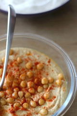 Bowl of homemade hummus served on a table. Selective focus.