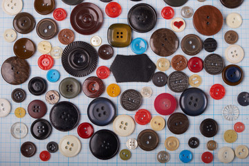 Colorful mixed sewing buttons on black background, flat lay. Top view.