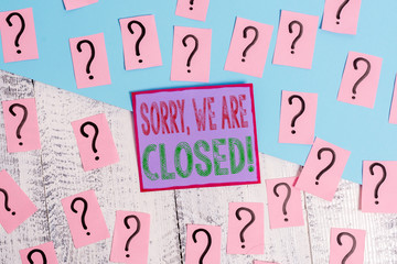 Handwriting text Sorry, We Are Closed. Conceptual photo apologize for shutting off business for specific time Scribbled and crumbling papers with thick cardboard above wooden table