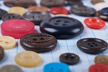 Colorful mixed sewing buttons on black background, flat lay. Top view.
