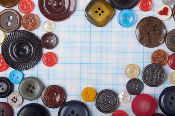 Colorful mixed sewing buttons on black background, flat lay. Top view.