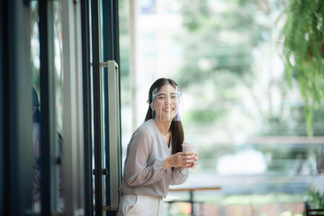 Portrait of an Asian woman wearing a face shield to protect her face to prevent the spread of the coronavirus, healthcare new normal lifestyle and social distancing concept