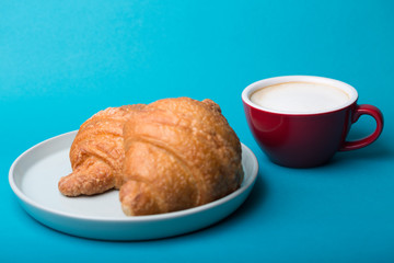 red cup with croissant on a blue background