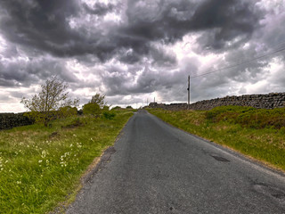 Fototapeta na wymiar Road in the countryside, with rain clouds, Haworth, Yorkshire England