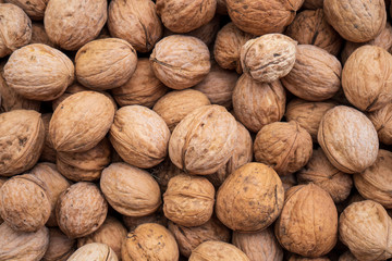 Natural walnut background pattern texture Abstract walnuts heap pattern background Blurred edges frame Natural food in-shell nuts walnuts pattern backdrop Walnuts in shell background dramatic contrast