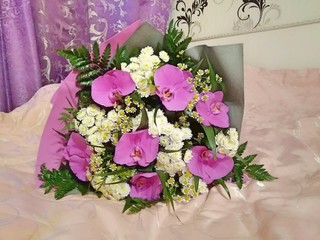 a bouquet of purple and white flowers close-up on the bed