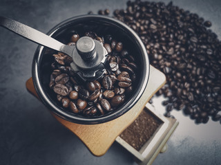 Roasted coffee beans in a coffee grinder on dark background