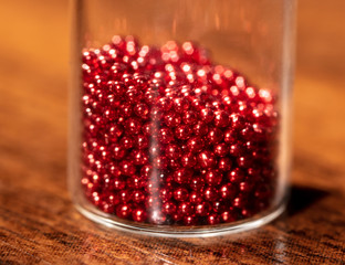 Red plastic balls in a glass jar.