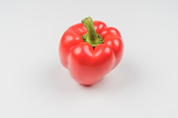 Ripe red pepper on a light background
