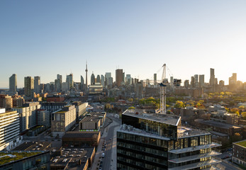 Toronto city center skyline with construction crane golden hour sunset light