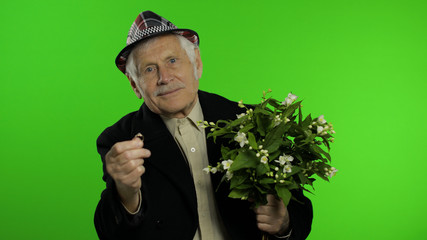 Elderly caucasian grandfather man with bouquet of flowers and ring goes on date