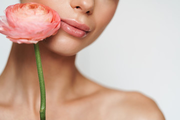 Cropped image of beautiful seductive shirtless woman posing with flower