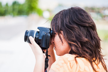 young girl taking photograph with reflex camera