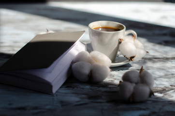 cup of coffee with a piece of chocolate and a notebook