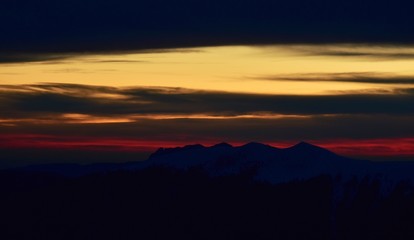 Fototapeta premium colorfully sunset over the mountains seen from high altitude