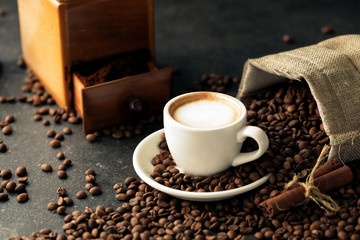 Sack of coffee beans poured on a cup of espresso