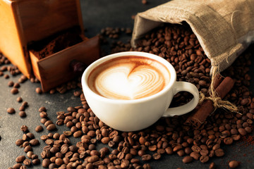 Sack of coffee beans poured on a cup of espresso