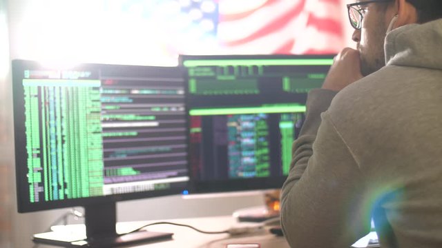 Programmer or hacker works at home in quarantine. Hacker code blinks of the monitor screen. Man writes code and programs. Internet online job. Self-isolation due to coronavirus