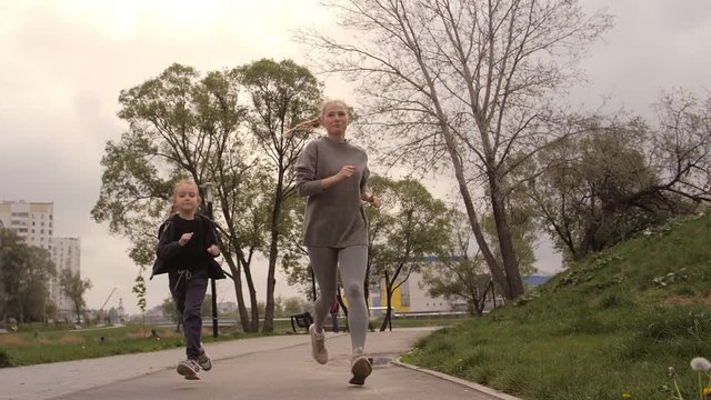 4K Mother and daughter running joggin outdoor in the park