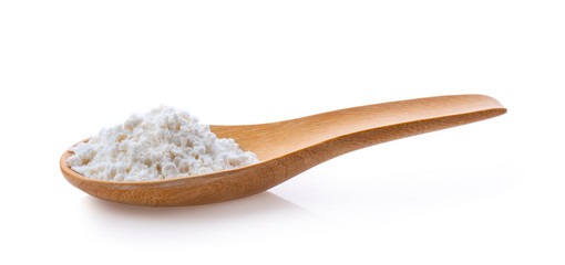 Fototapeta na wymiar Pile of white wheat flour in wooden spoon on white background