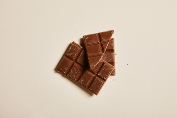 top view of sweet milk chocolate on beige background