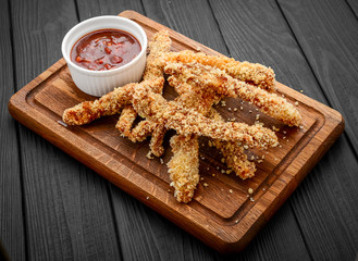 Fried crispy chicken nuggets with ketchup on white board