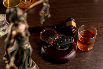 Car keys and glass of alcohol on table in pub or restaurant.