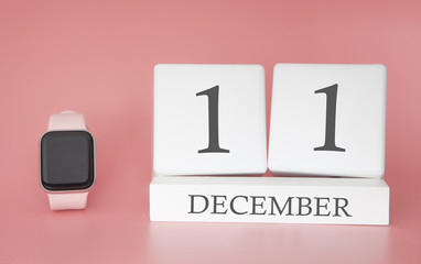 Modern Watch with cube calendar and date 11 december on pink background. Concept winter time vacation.