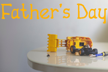 Father's day congratulation holiday concept repair toys disassembled tractor screwdriver