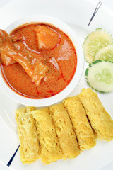 Traditional Malay snack food Roti Jala served with curry chicken with potato on white ceramic plate and bowl