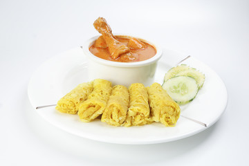 Traditional Malay snack food Roti Jala served with curry chicken with potato on white ceramic plate and bowl