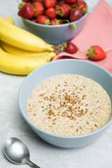 Flax porridge with banana and strawberries on a light background. Healthy breakfast