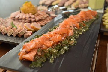 Salmon gravlax with dill jelly served on a black plate for banquet