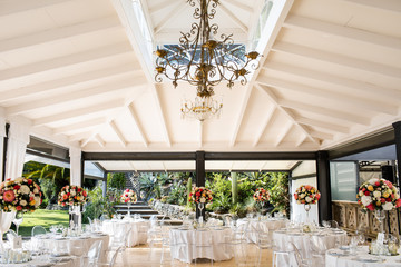 in backyard of villa in Tuscany there is banquet wooden table decorated with cotton and eucalyptus compositions