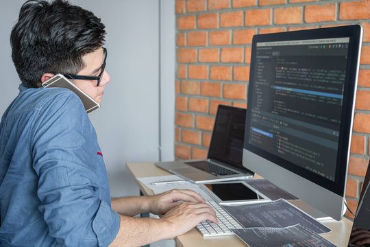 Young Professional programmer working at developing programming and website working in a software develop company office, writing codes and typing data code, Programming with HTML, PHP and javascript
