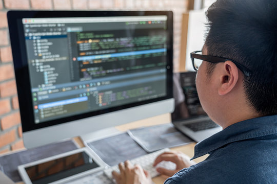 Young Professional programmer working at developing programming and website working in a software develop company office, writing codes and typing data code, Programming with HTML, PHP and javascript